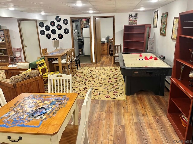 interior space with a paneled ceiling and wood finished floors