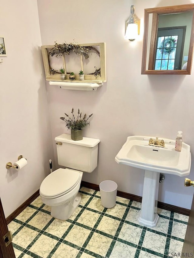 bathroom with toilet and baseboards