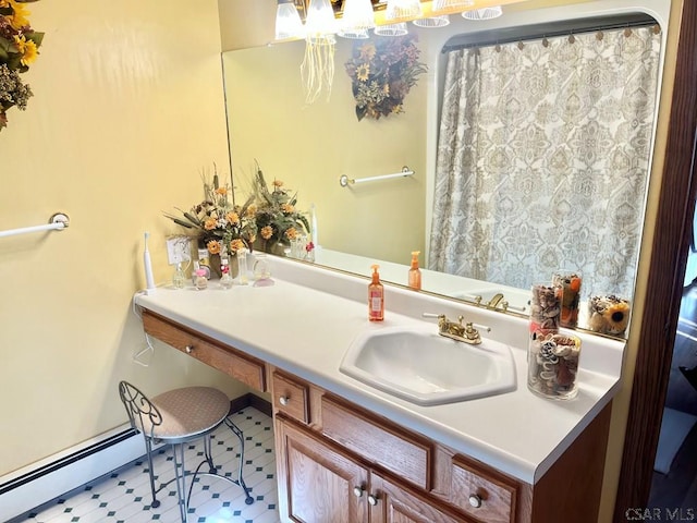 bathroom featuring baseboard heating and vanity