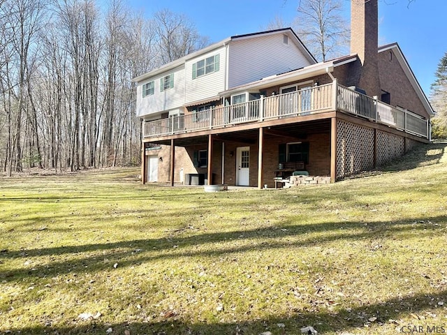 back of property with a wooden deck, a chimney, and a yard