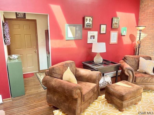 living room featuring baseboards, baseboard heating, and wood finished floors