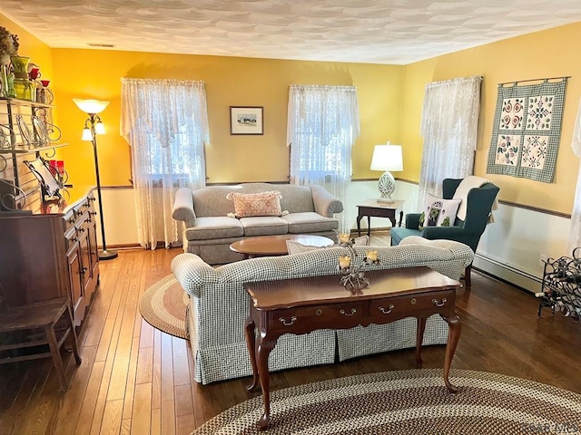 living room with a baseboard radiator, a textured ceiling, and light wood-style flooring