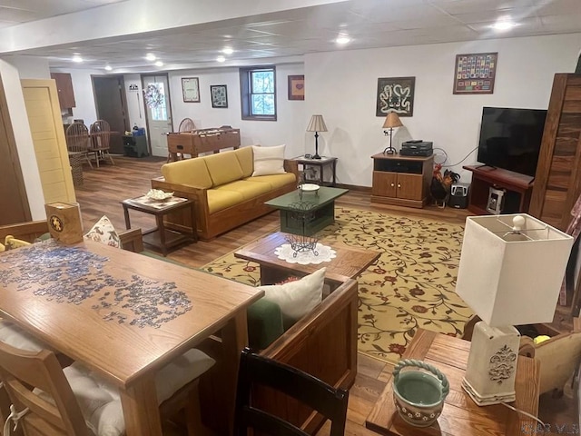 living area featuring wood finished floors and a paneled ceiling