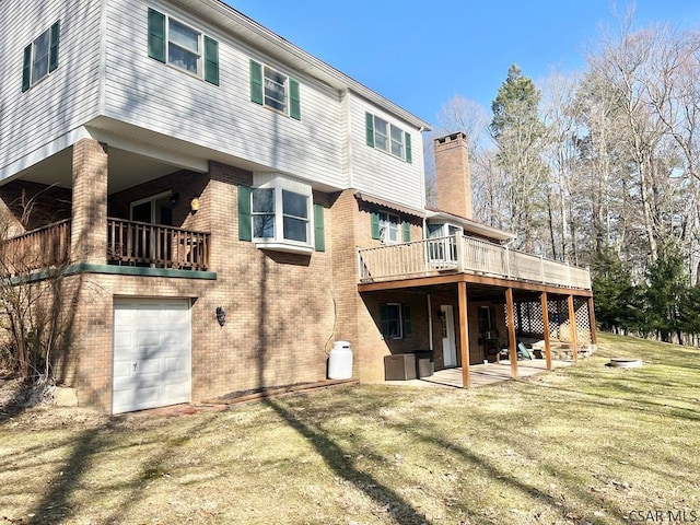 back of house featuring brick siding, a chimney, a yard, a garage, and a patio