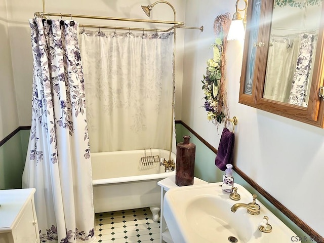 bathroom with shower / bathtub combination with curtain and a sink