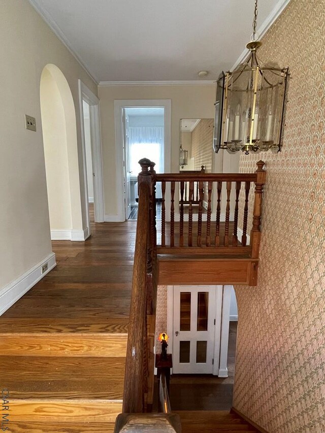 stairs featuring ornamental molding and wood-type flooring