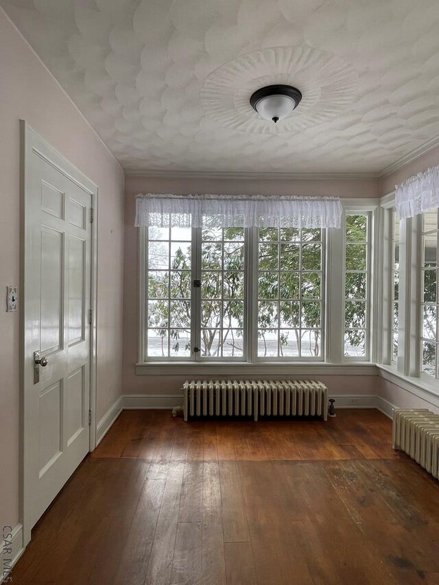 unfurnished sunroom featuring radiator