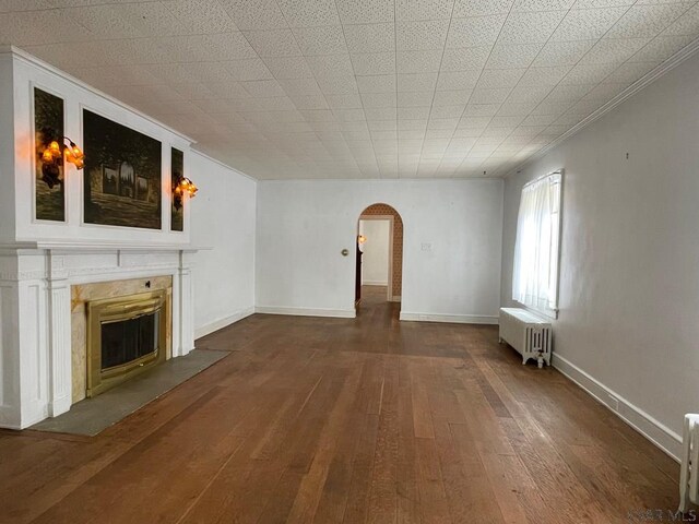 unfurnished living room featuring radiator heating unit and wood-type flooring