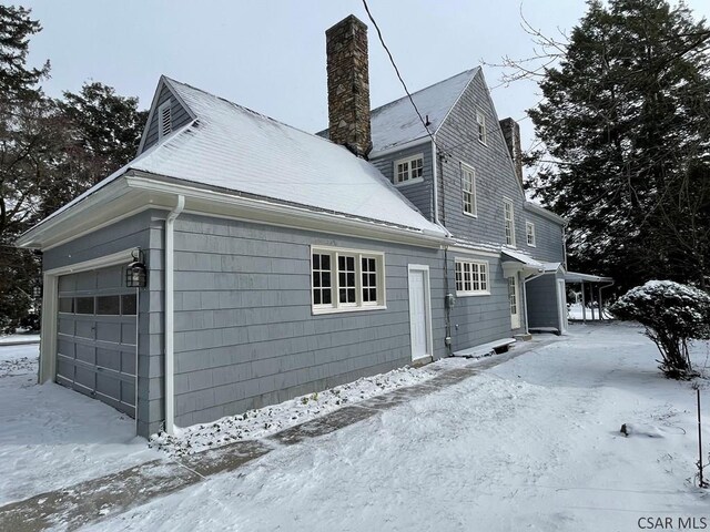 snow covered property featuring a garage