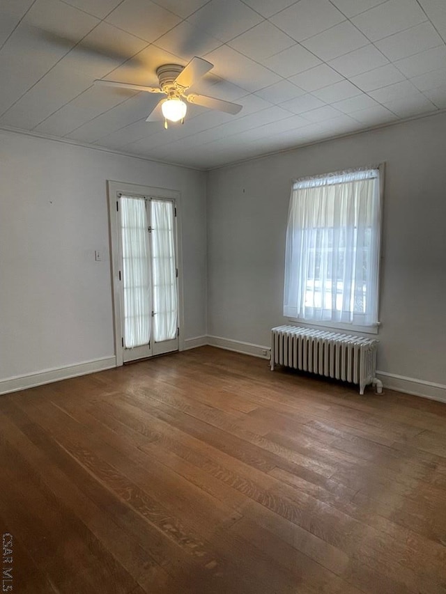 unfurnished room featuring ceiling fan, wood-type flooring, and radiator