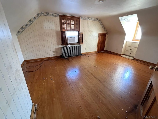 bonus room featuring wood-type flooring, lofted ceiling, radiator, and cooling unit