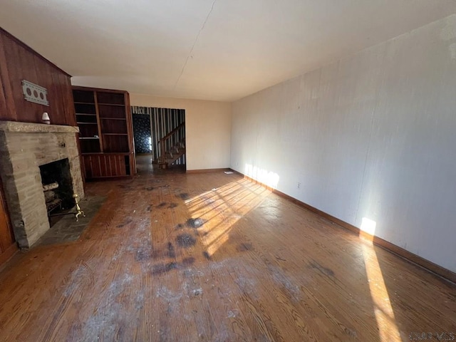 unfurnished living room with dark wood-type flooring and a fireplace