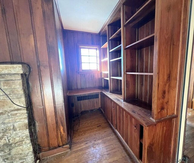 unfurnished office featuring wood-type flooring, ornamental molding, and wooden walls