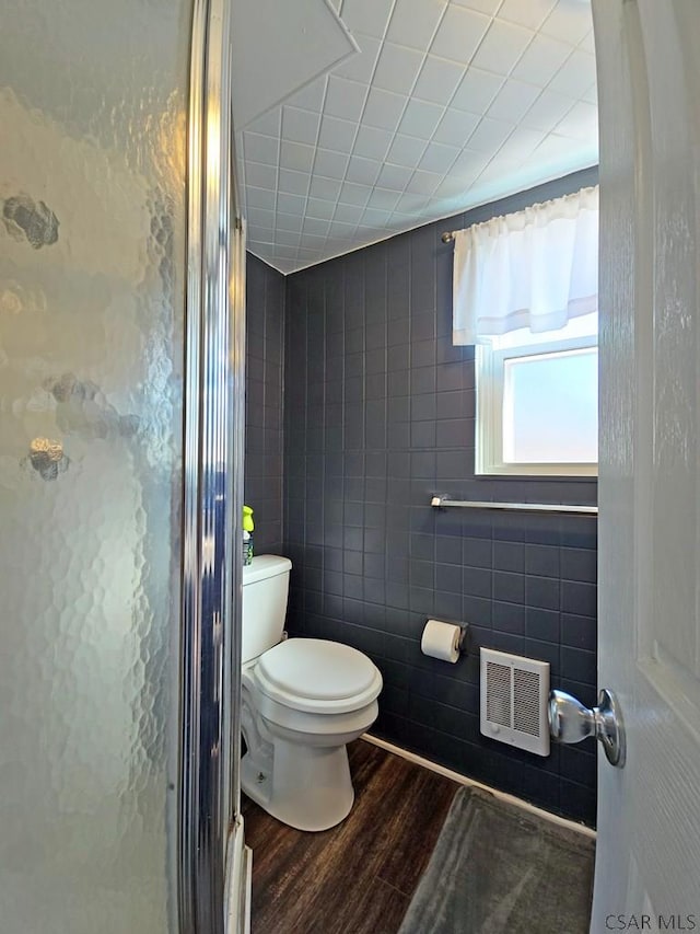 bathroom featuring wood-type flooring, toilet, and walk in shower