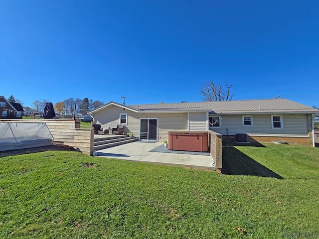 back of property featuring a yard, outdoor lounge area, a patio, central AC unit, and a hot tub