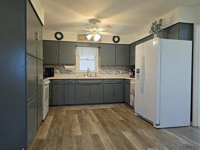 kitchen with sink, backsplash, hardwood / wood-style flooring, ceiling fan, and white appliances