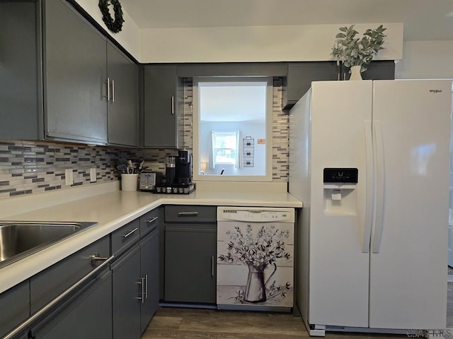 kitchen featuring gray cabinets, dark wood-type flooring, white appliances, and decorative backsplash