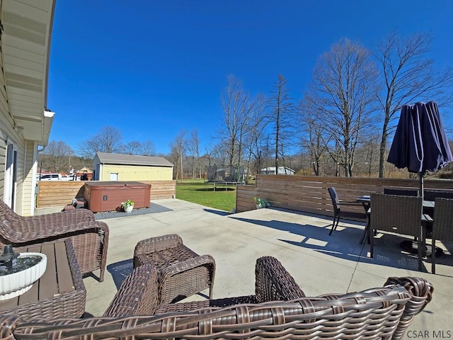 view of patio / terrace with a hot tub and a trampoline