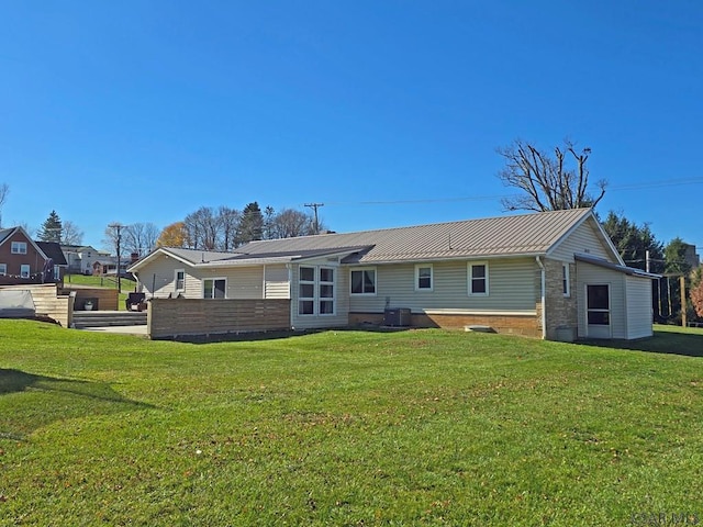 rear view of house with a yard and central AC unit