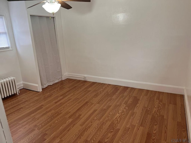 spare room with ceiling fan, radiator, and light hardwood / wood-style flooring