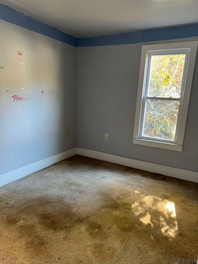 empty room featuring carpet floors and baseboards