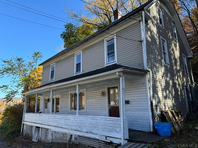 view of front facade with a chimney and a porch