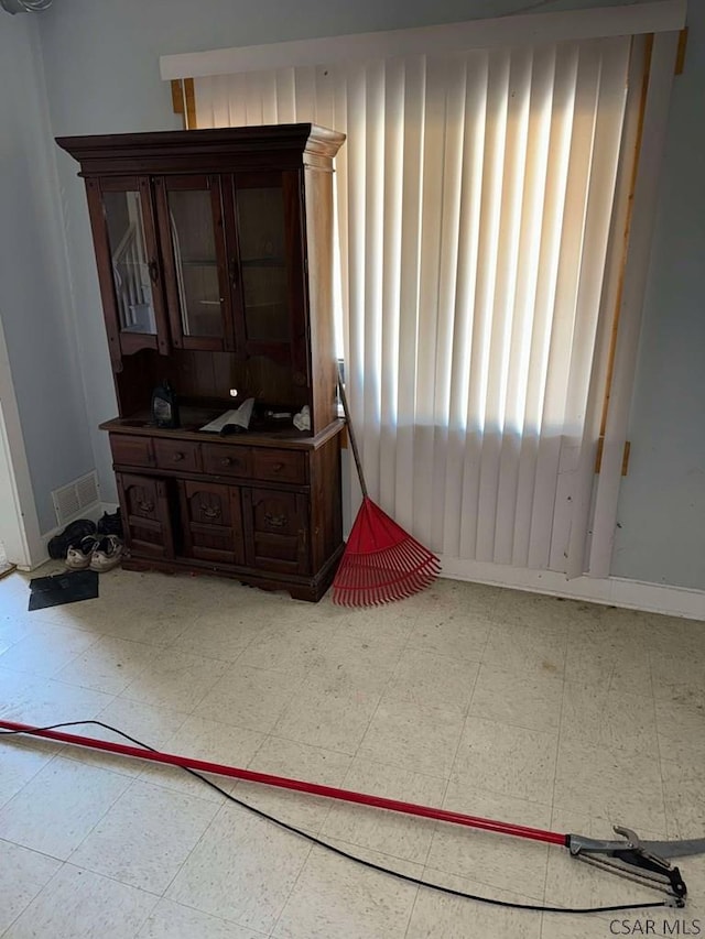 interior space featuring baseboards, visible vents, and tile patterned floors