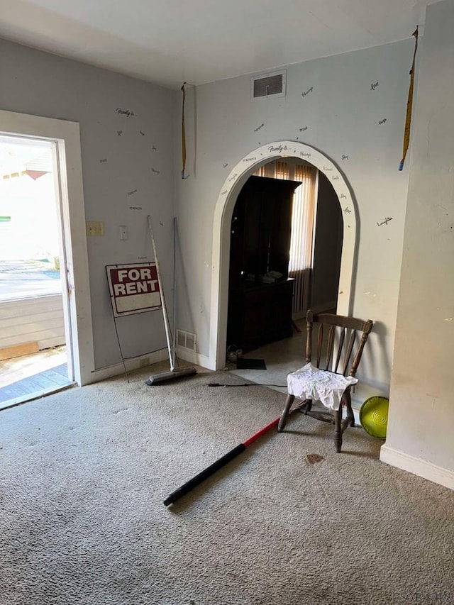 interior space with arched walkways, carpet flooring, and visible vents