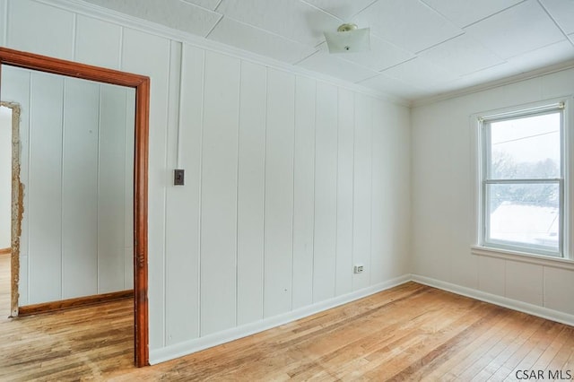 unfurnished room featuring crown molding and light wood-type flooring