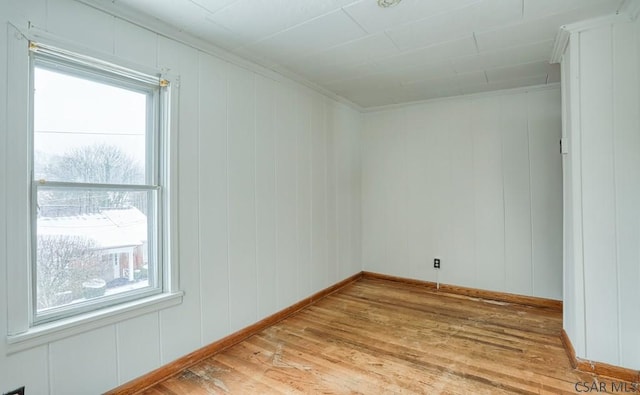 spare room featuring ornamental molding and light hardwood / wood-style floors