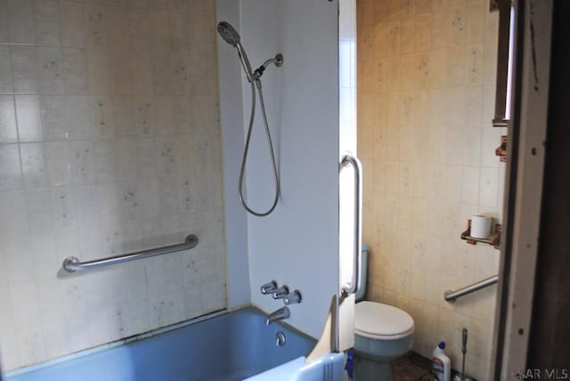 bathroom featuring toilet, bathing tub / shower combination, and tile walls