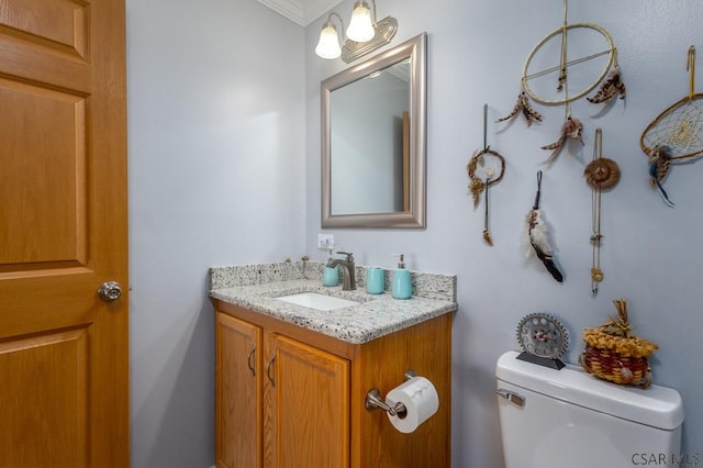 bathroom featuring vanity, ornamental molding, and toilet