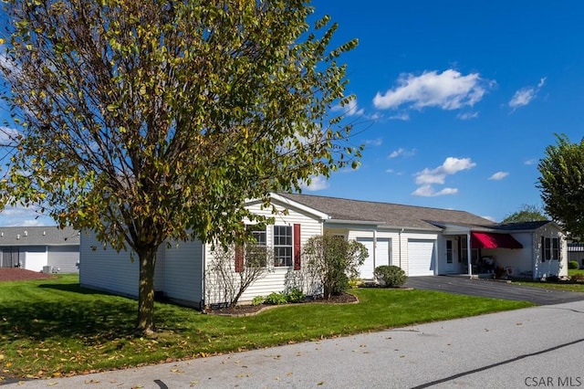 single story home featuring a garage and a front lawn