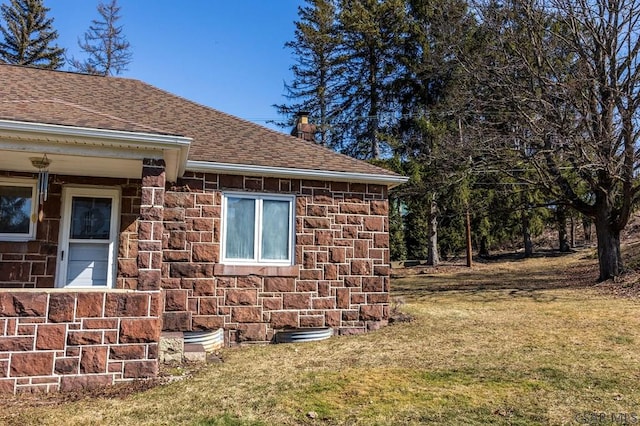 view of home's exterior featuring brick siding, a shingled roof, a lawn, a chimney, and stone siding