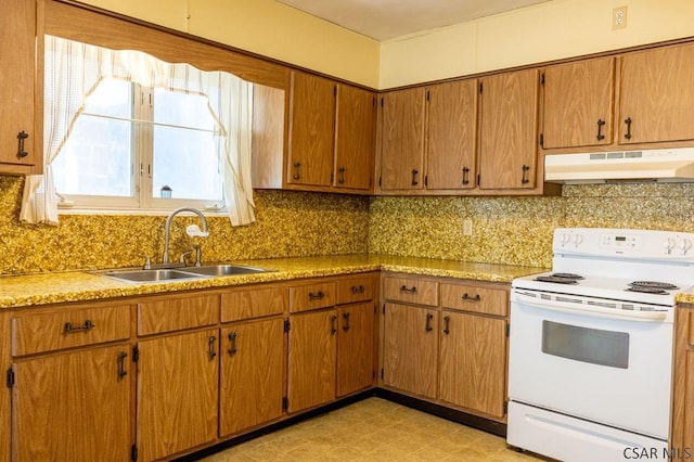 kitchen with light floors, a sink, electric stove, under cabinet range hood, and backsplash