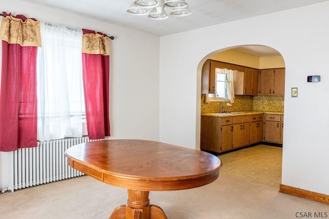 dining area with arched walkways and radiator