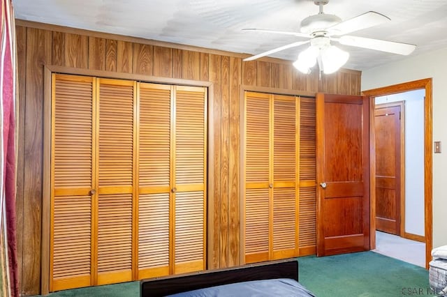 interior space with carpet floors, two closets, and a ceiling fan