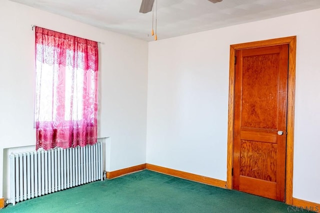 carpeted empty room featuring radiator, baseboards, and ceiling fan