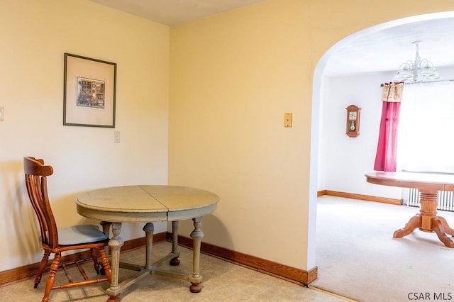 dining area featuring a notable chandelier, baseboards, and arched walkways