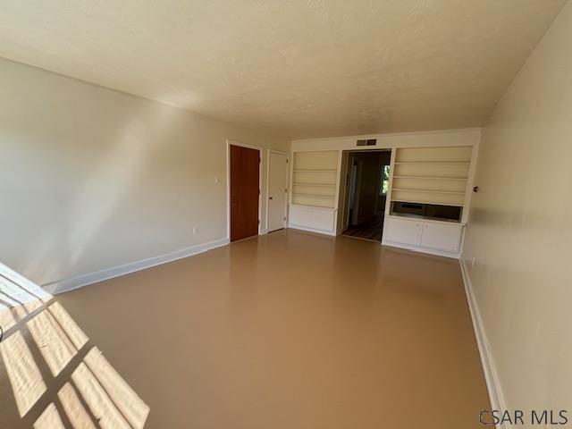 spare room featuring built in shelves