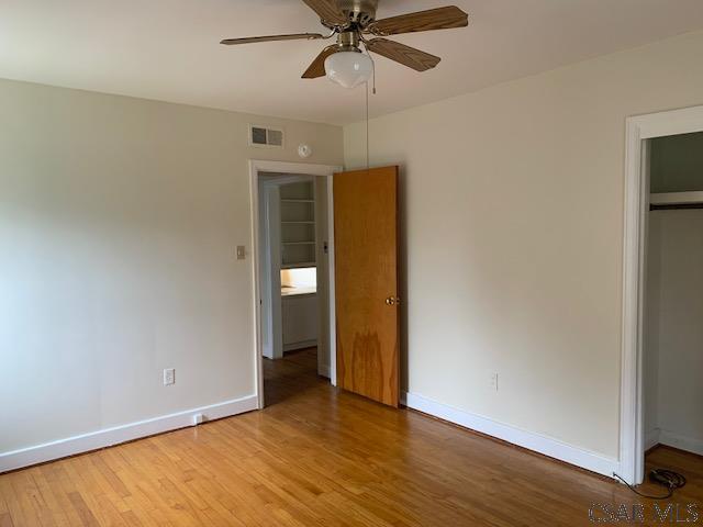 unfurnished bedroom featuring hardwood / wood-style flooring, ceiling fan, and a closet