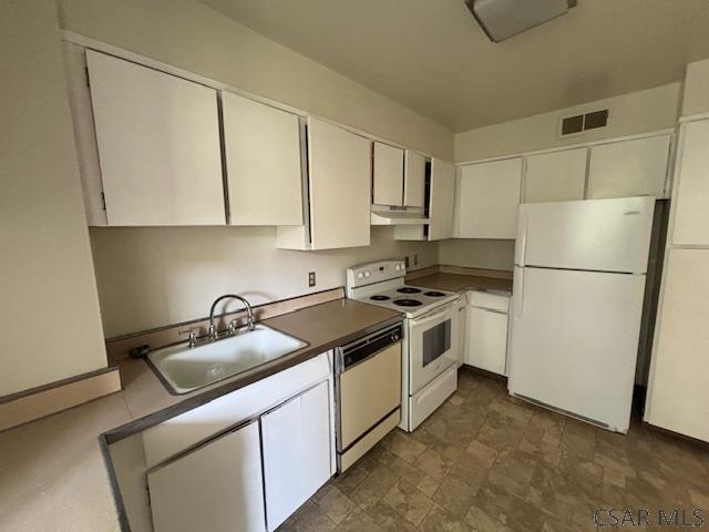 kitchen with white appliances, sink, and white cabinets