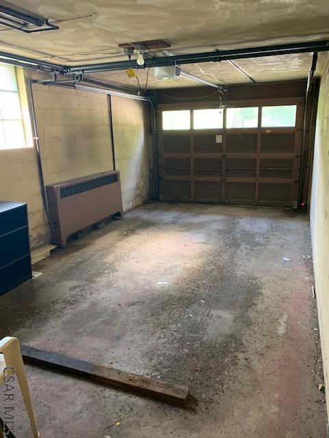 garage with a garage door opener and radiator