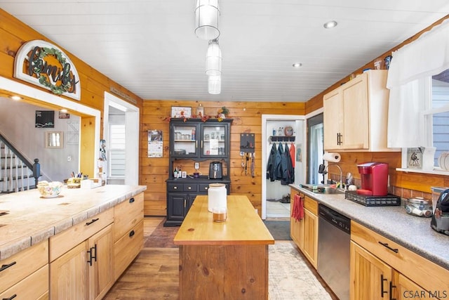 kitchen with sink, wood walls, wooden counters, dishwasher, and a kitchen island