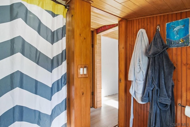 bathroom with hardwood / wood-style floors, wooden ceiling, wooden walls, and a shower with curtain