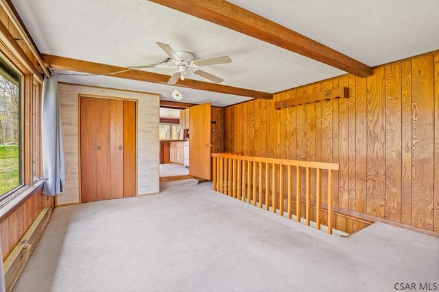 706 Laurel Summit Rd, Boswell, PA 15531 - carpeted empty room featuring plenty of natural light, beam ceiling, wood walls, a ceiling fan, and a textured ceiling