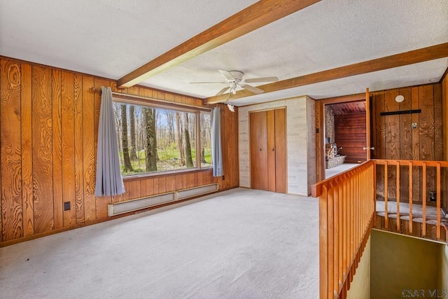 706 Laurel Summit Rd, Boswell, PA 15531 - empty room featuring baseboard heating, wooden walls, beam ceiling, carpet, and a ceiling fan