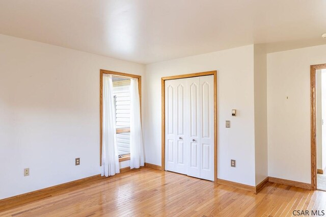 unfurnished bedroom with light hardwood / wood-style floors and a closet