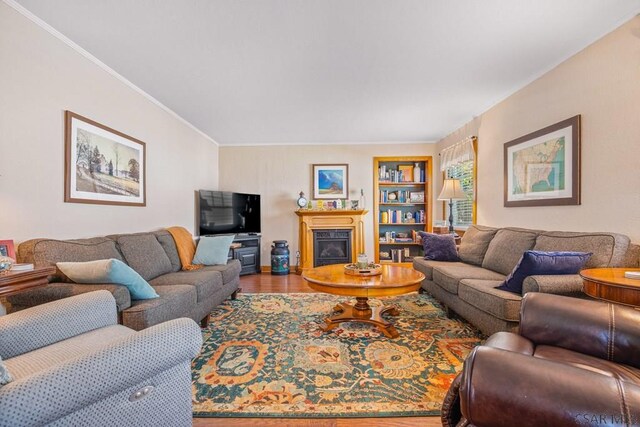 352 W Garrett St, Somerset, PA 15501 - living area featuring a glass covered fireplace, wood finished floors, built in shelves, and ornamental molding