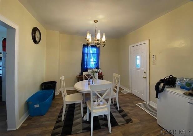 dining area featuring dark hardwood / wood-style floors and a notable chandelier